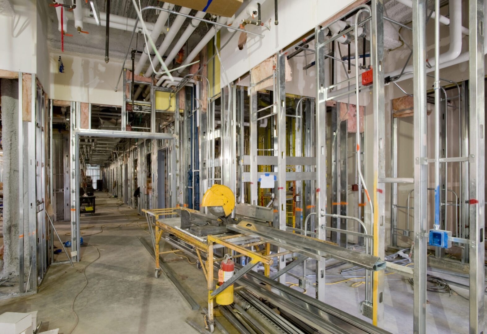 Rough-in plumbing and mechanical with steel framing during hospital construction.